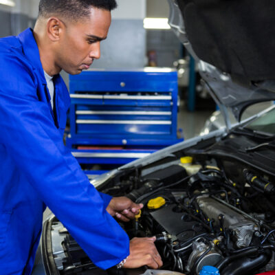 Mechanic examining car engine